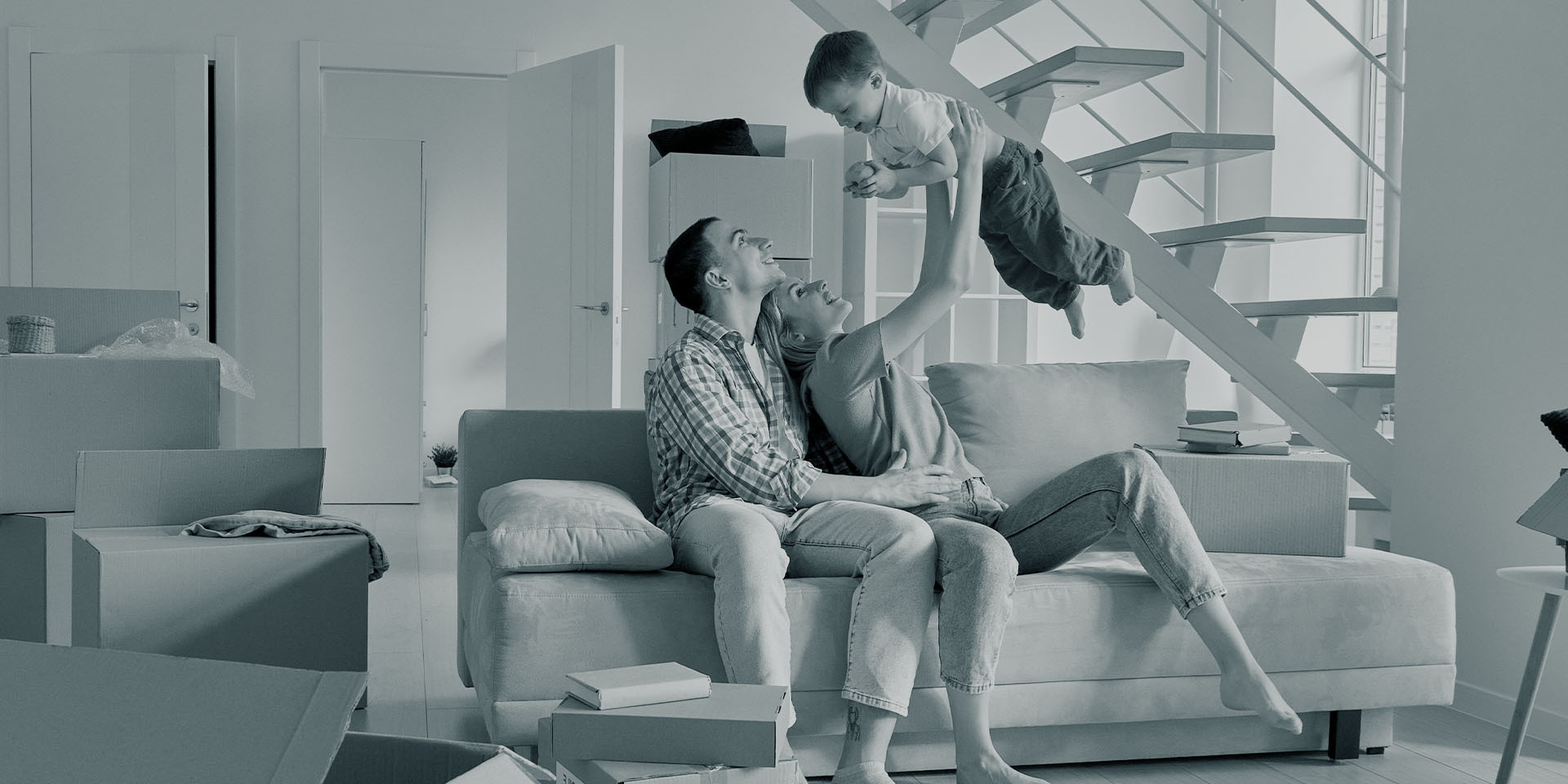 A young family moving into their new home, laughing and playing together.